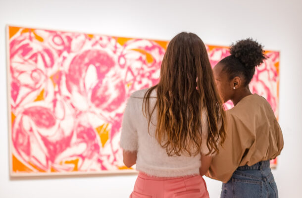 zwei Mädchen stehen vor einem Gemälde
